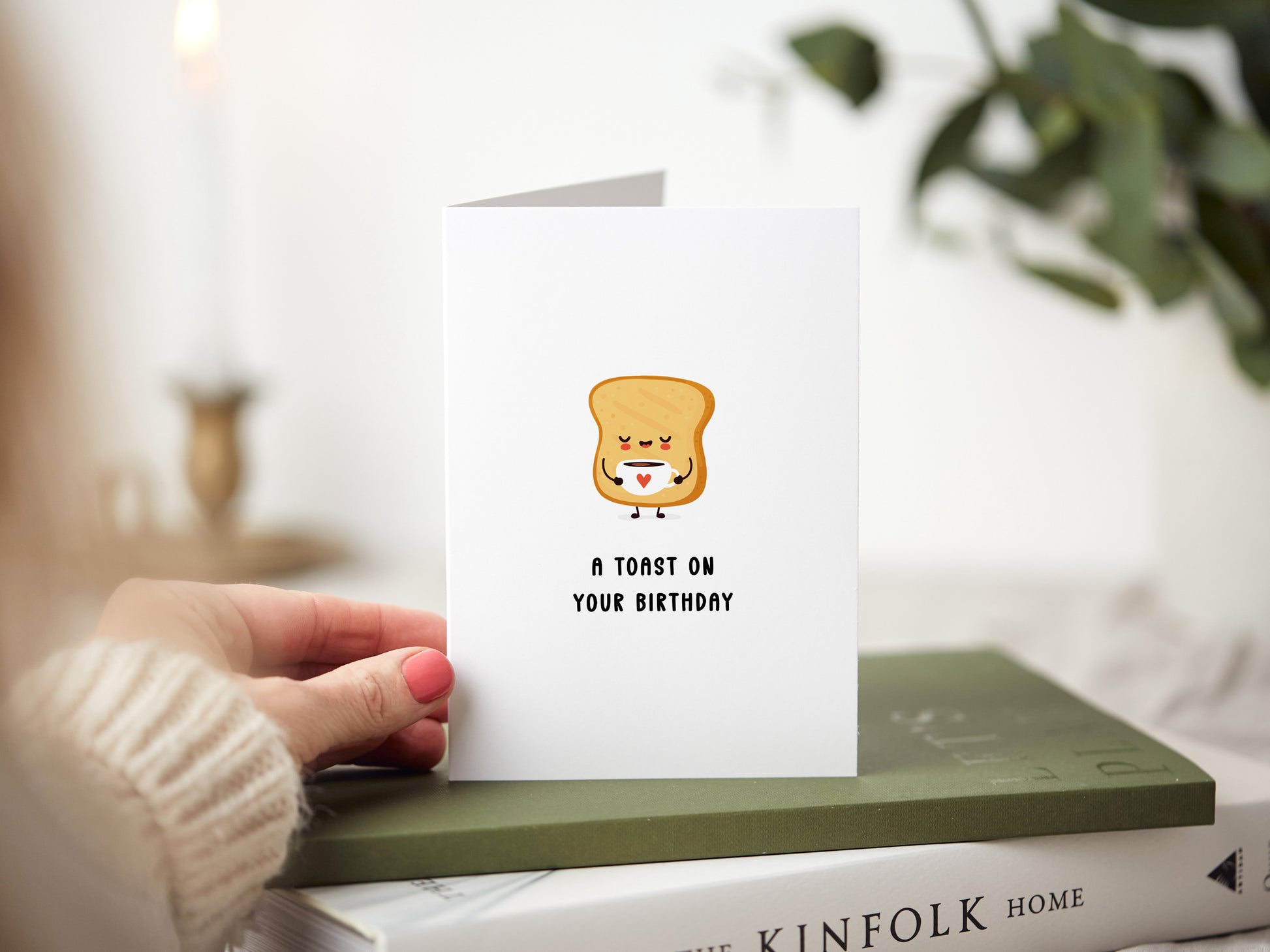 A birthday card which reads 'a toast on your birthday' with a slice of toast having a cup of tea.