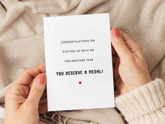 Anniversary card which reads 'congratulations on putting up with me for another year. You deserve a medal'.