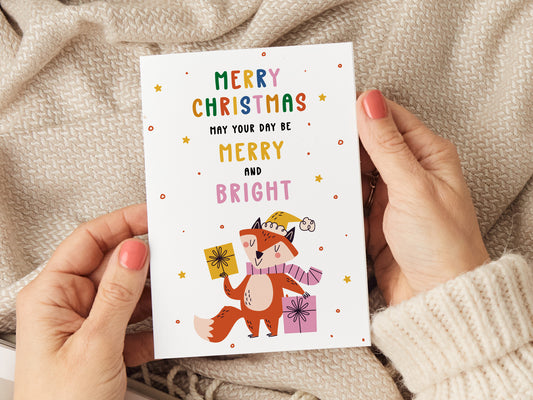 Christmas card which reads 'merry christmas may your day be merry and bright' and has an illustration of a fox holding two presents.