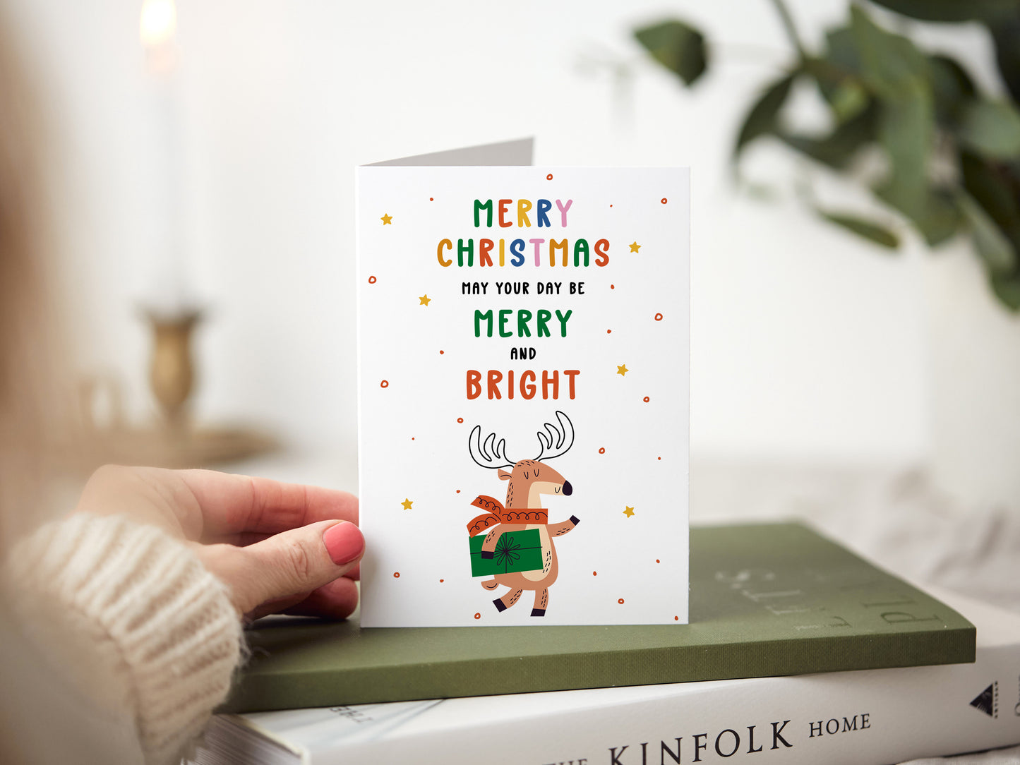 Christmas card which reads 'merry Christmas may your day be merry and bright' with an illustration of a reindeer holding a present.