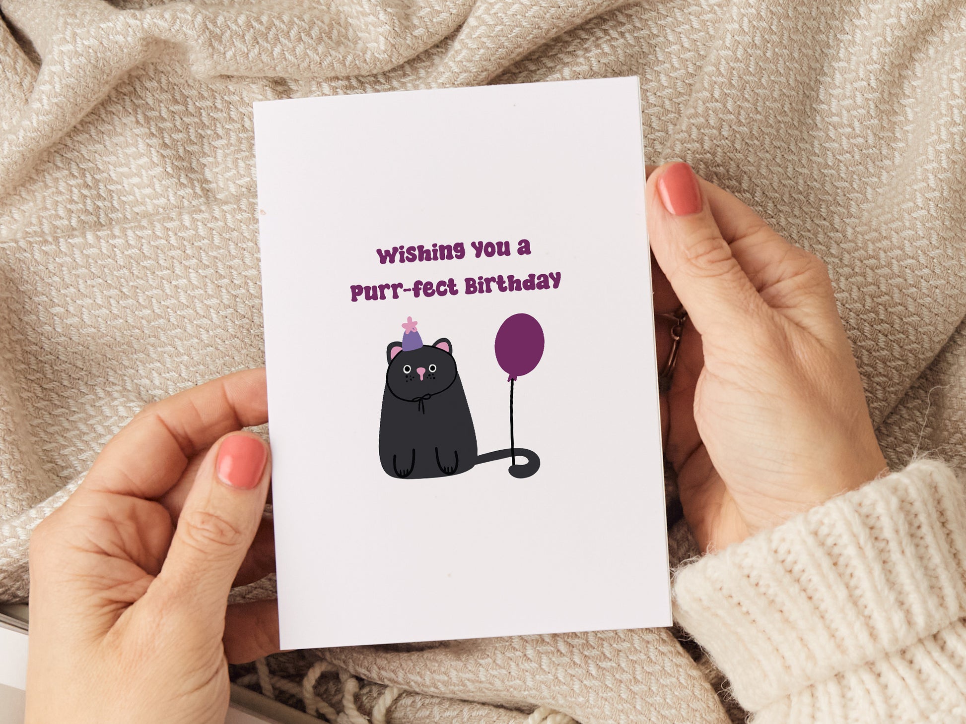 Birthday card which reads 'wishing you a pur-fect birthday' and has a illustration of a cat wearing a birthday hat and has a birthday balloon.